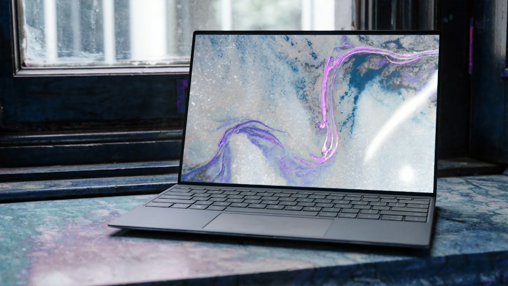 Open laptop computer on a marble surface