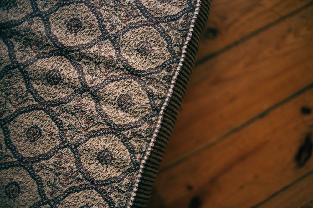 Close-up of a patterned mattress beside a wooden floor